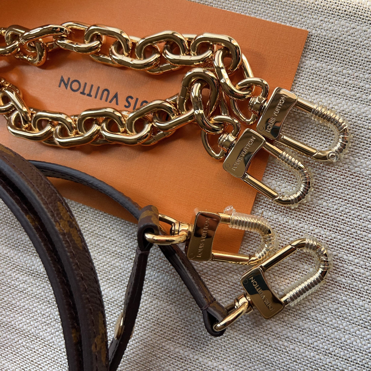 Gold chain strap on a Louis Vuitton handbag with a visible brand logo.
