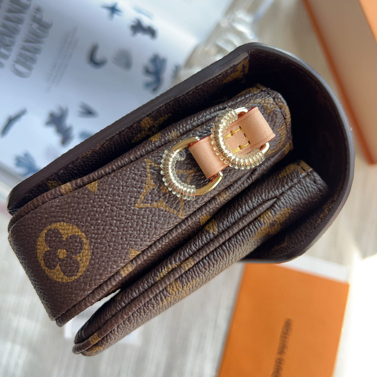 Designer wallet with gold accents on a blurred background