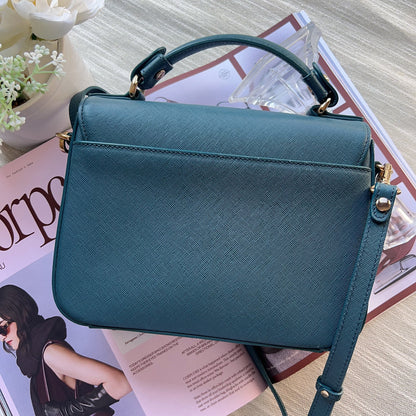 Teal handbag on a magazine with a blurred background