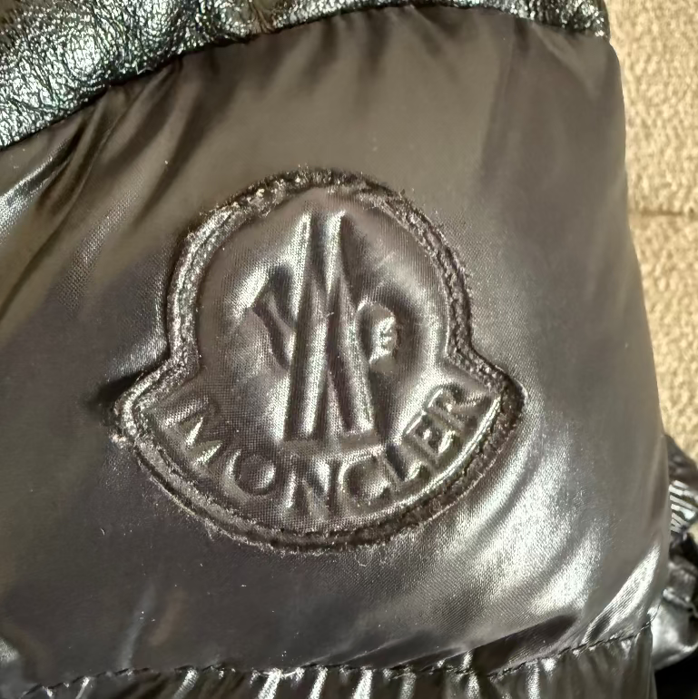Close-up of a Moncler logo on a metallic surface