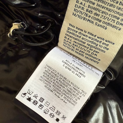Close-up of a label on a black garment with text and symbols.