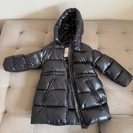 Black puffer jacket on a beige couch