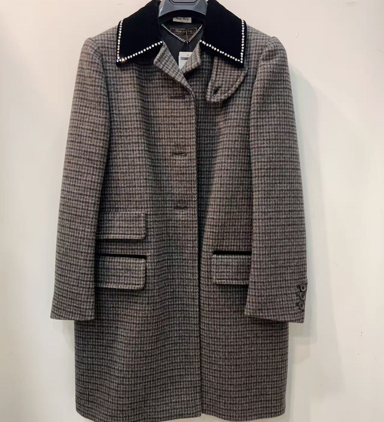 Houndstooth pattern coat with black collar on a white background