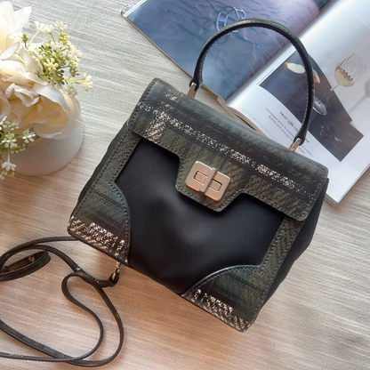 Handbag with a strap on a table next to flowers and a magazine