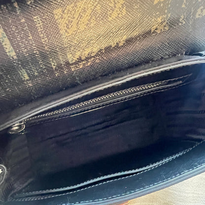 Close-up of a black leather bag with a zipper on a textured surface