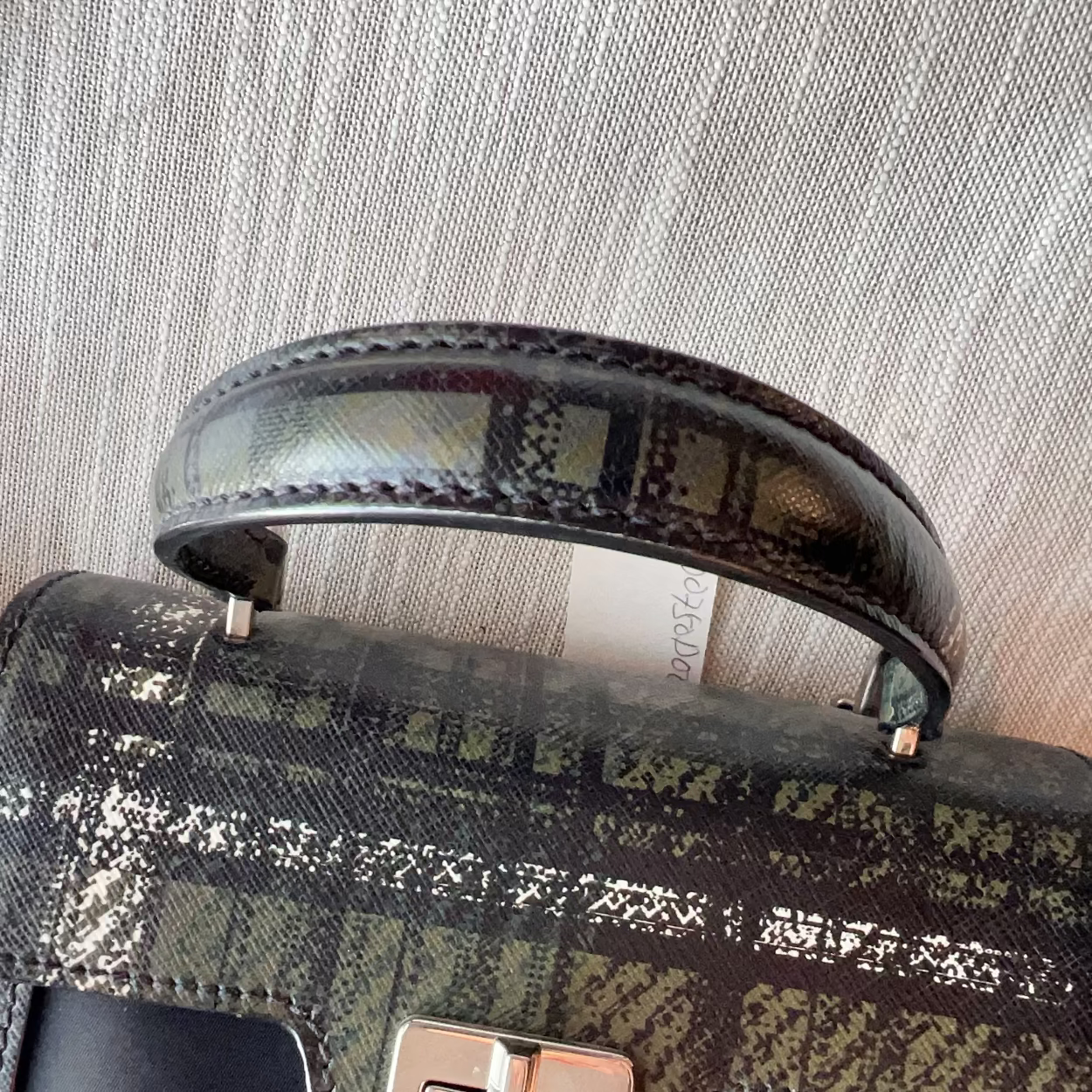 Patterned handbag with a textured handle on a neutral background