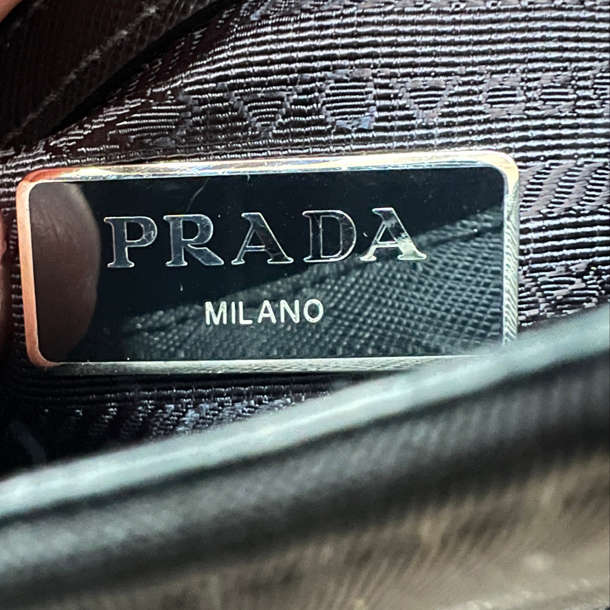 Close-up of a Prada logo on a textured surface
