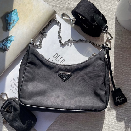 Gray handbag with Prada logo on a textured surface