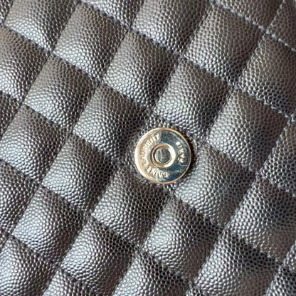 Close-up of a black quilted caviar leather bag with a silver-tone metal snap button.