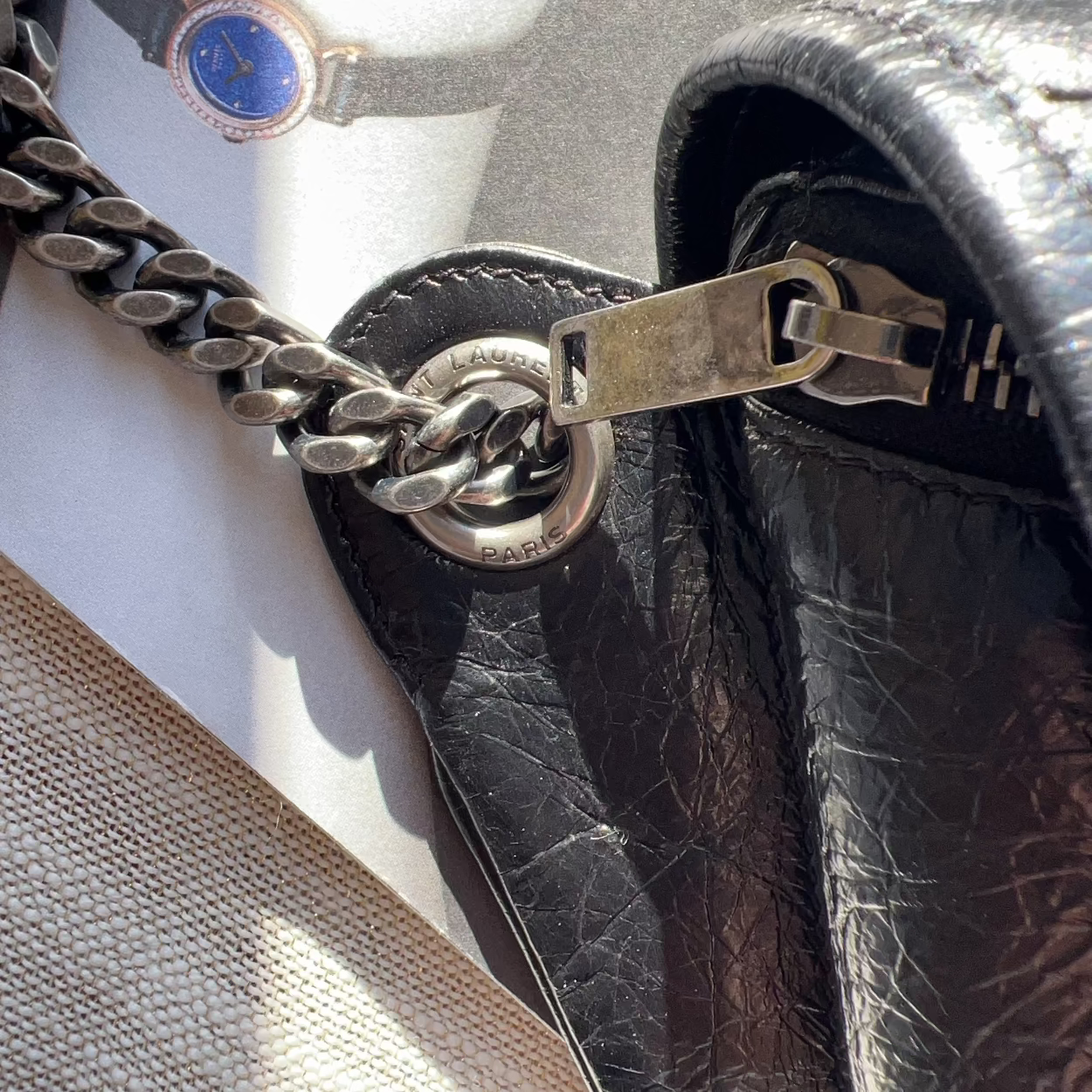 Close-up of a leather handbag with a chain detail on a mannequin.