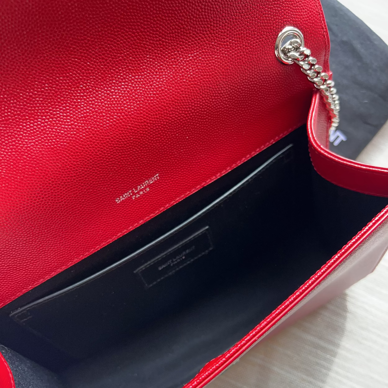 Red handbag with visible brand logo on a light gray background