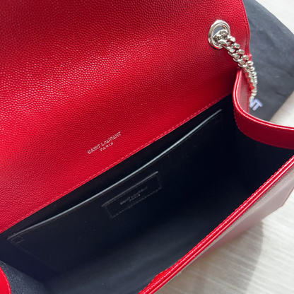 Red handbag with visible brand logo on a light gray background