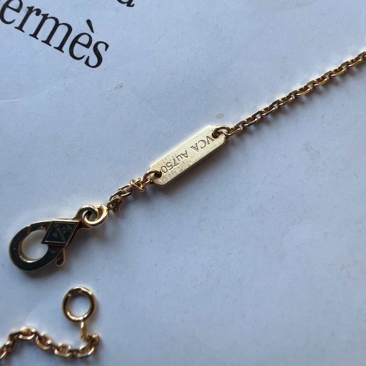 Gold necklace with a tag on a white background