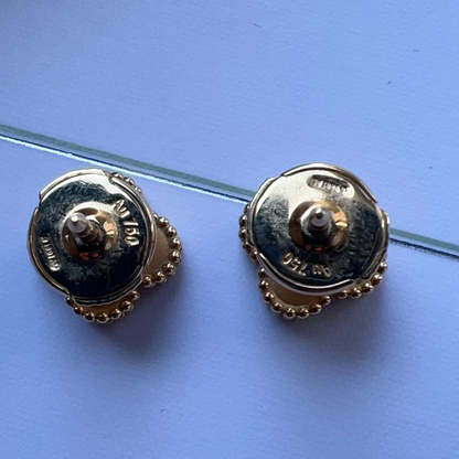 Pair of gold earrings on a blue background