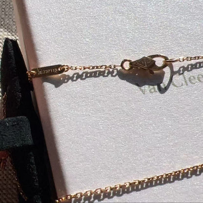 A close-up of a delicate gold chain bracelet with a diamond-shaped clasp resting on a white jewelry box. The brand name 'Van Cleef' is partially visible on the box, and the inside of the clasp shows the engraving 'VAC 137110'.