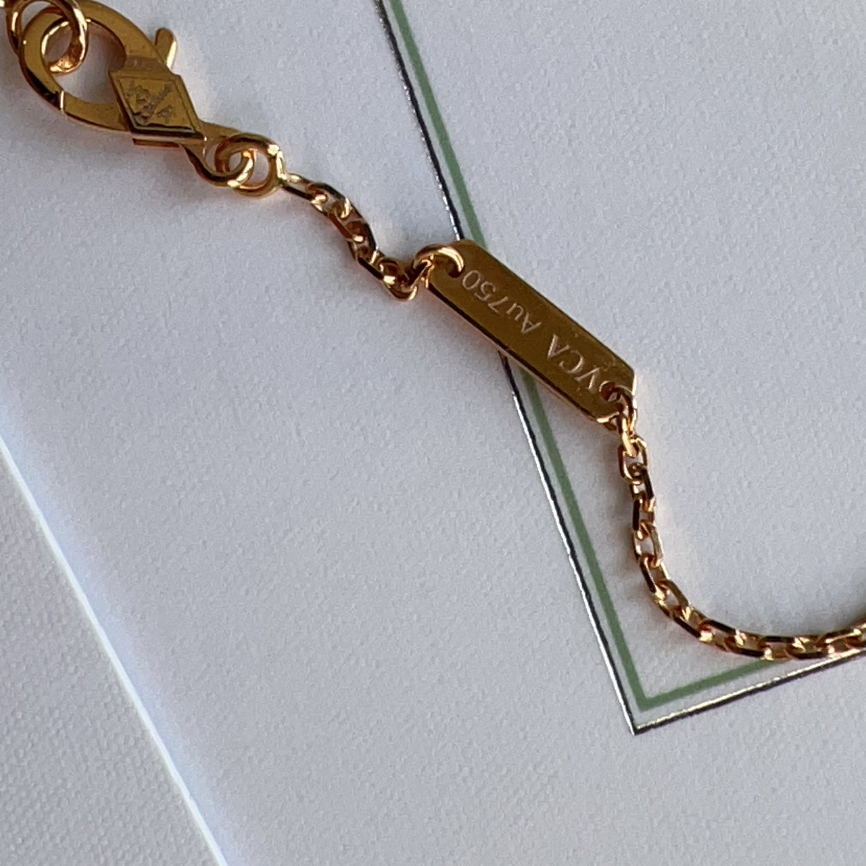 Gold bracelet with a nameplate on a white background