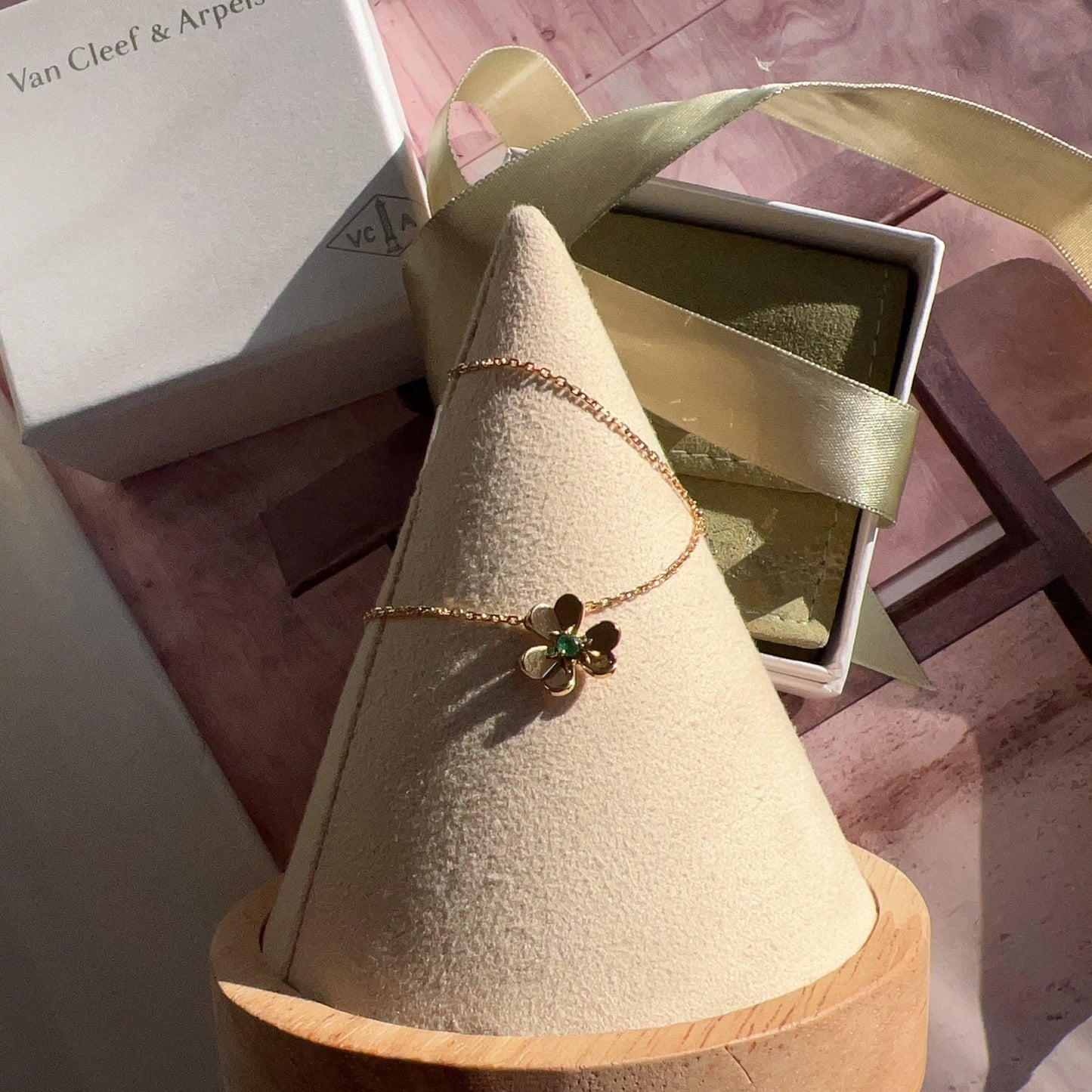 Van Cleef & Arpels necklace on a cone-shaped display with a box in the background.