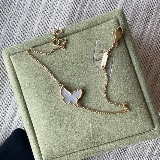 Gold necklace on a green jewelry box with a white cloth background
