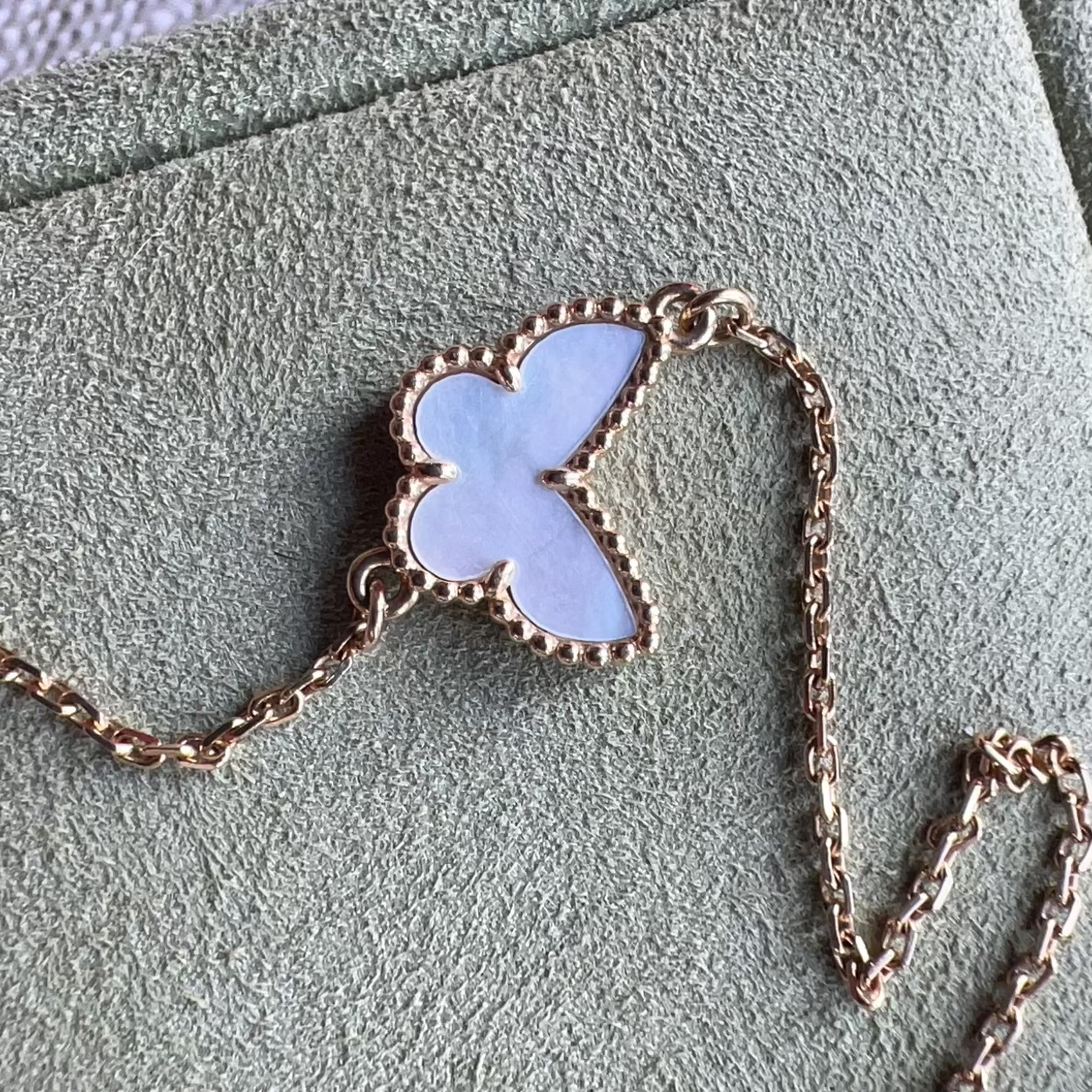 Necklace with a butterfly pendant on a textured surface