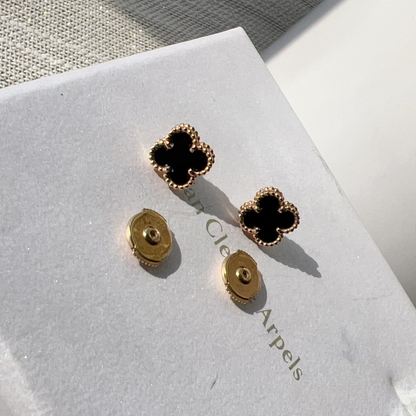 Gold and black earrings on a Cleo Arpels card