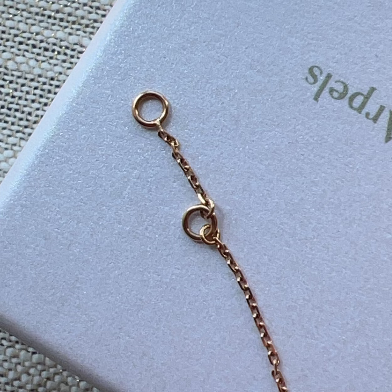 Rose gold necklace chain on a light blue card with 'Arpeles' branding.
