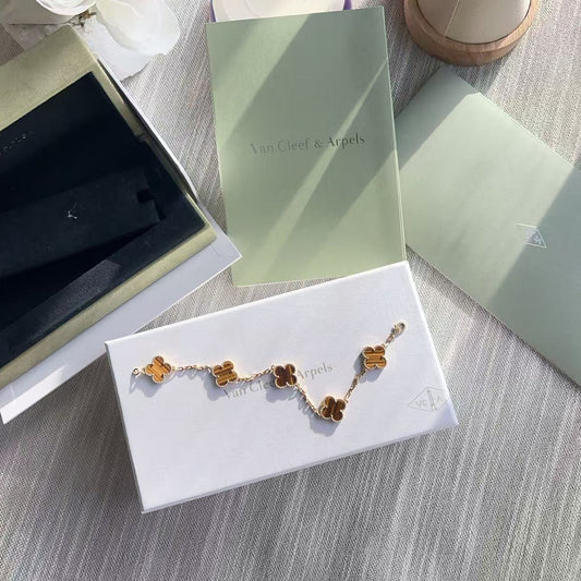 Gold bracelet on a white card with a green box in the background