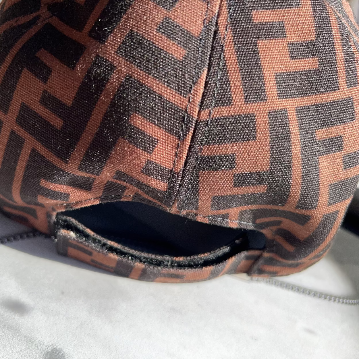 Brown and black patterned cap on a light gray surface